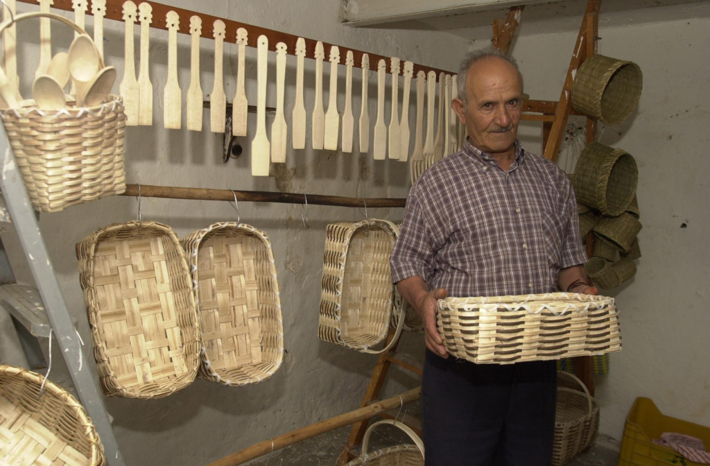 Cestaio che mostra il suo lavoro tenendo un cesto artigianale tra le mani